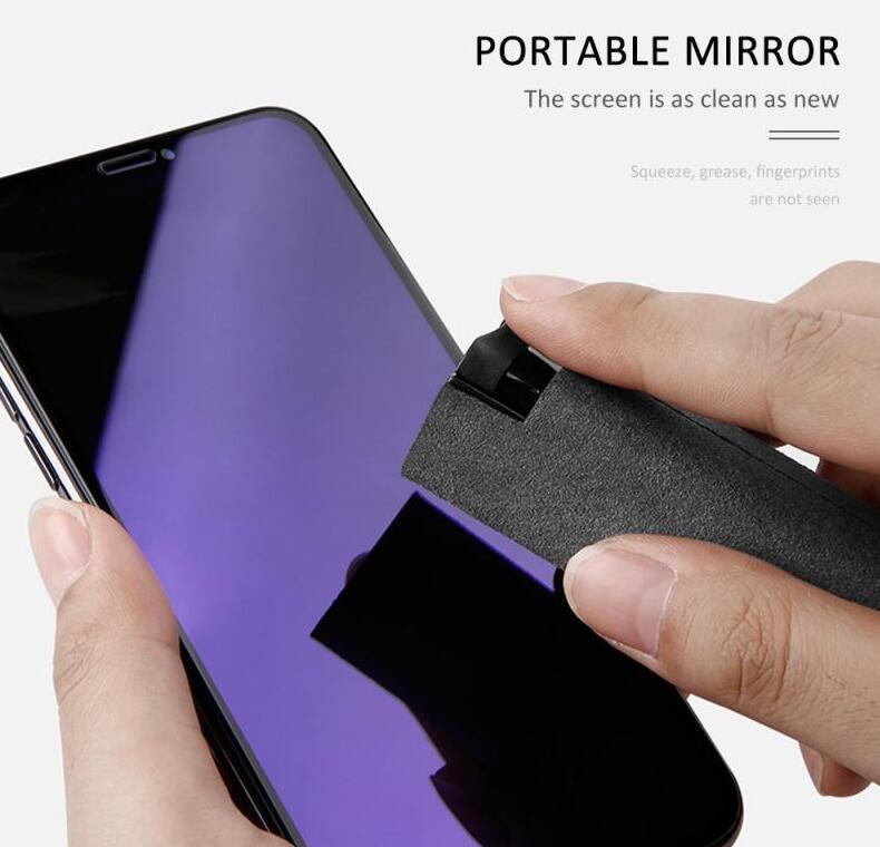 Hand using a portable mirror to clean a smartphone screen on a white background