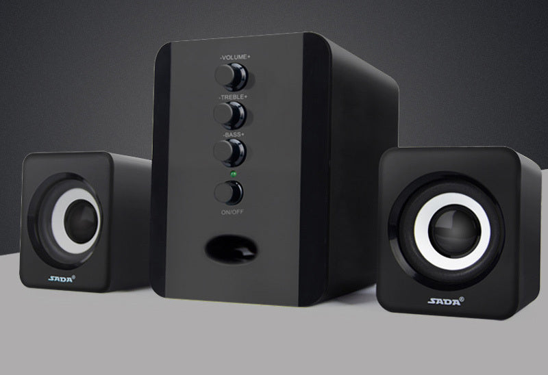 Black computer speakers with control panel on a gray background