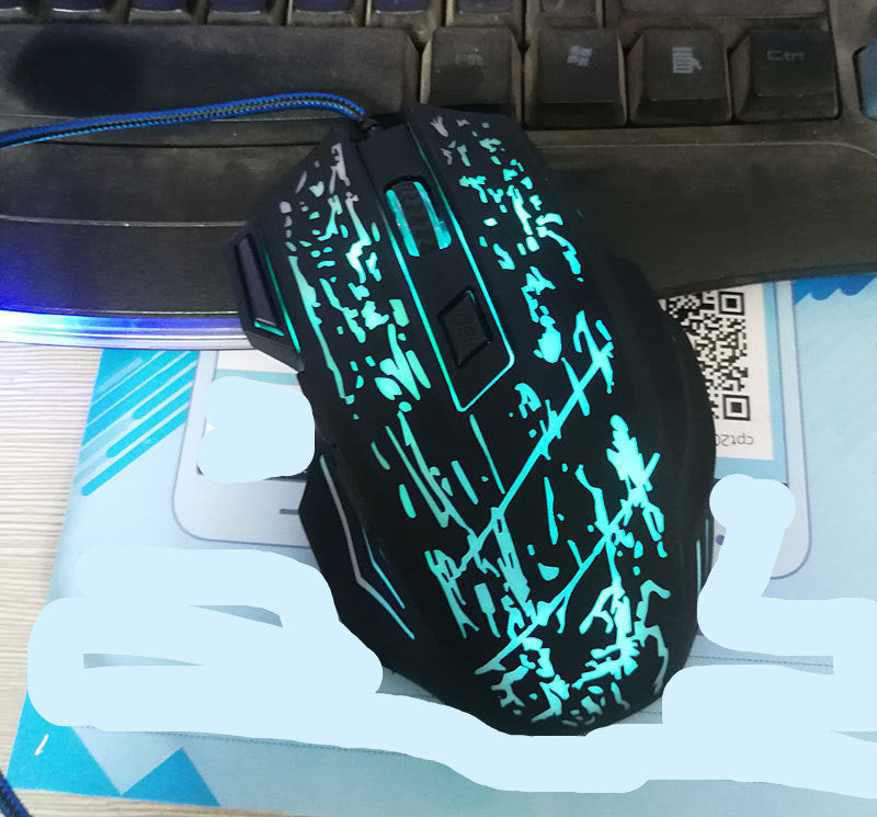 Glowing blue gaming mouse on a desk with keyboard and mouse pad in the background