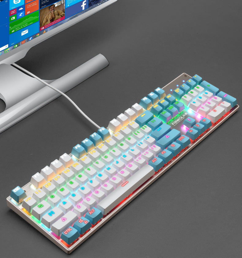 Colorful mechanical keyboard on a dark surface with a computer monitor in the background