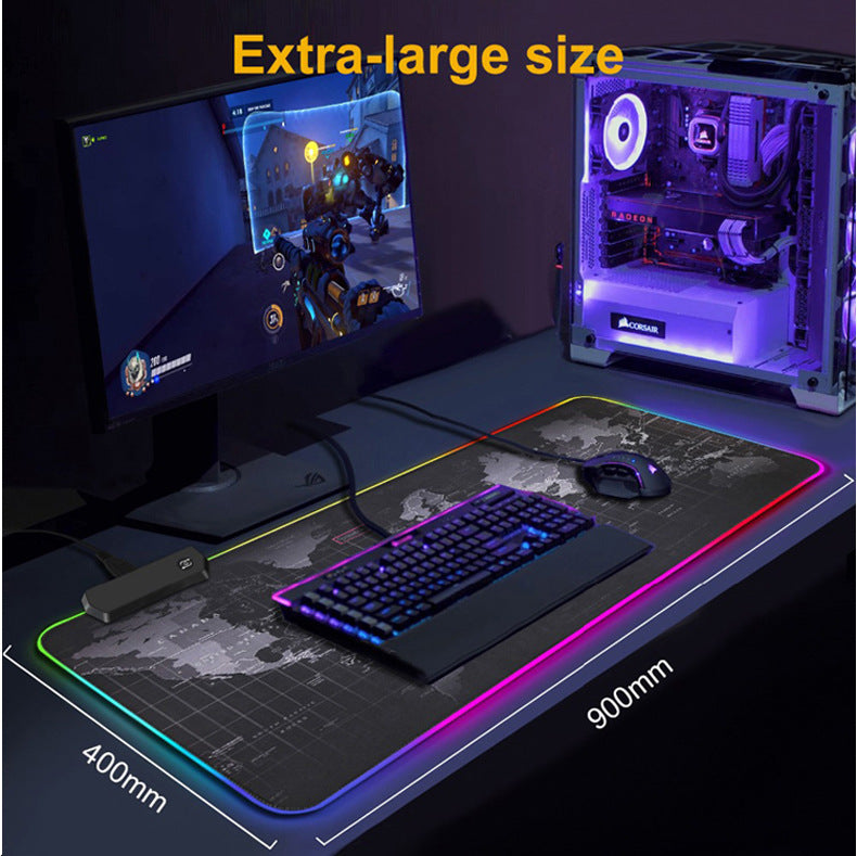 Gaming setup with monitor, keyboard, mouse, and large mouse pad on a desk.