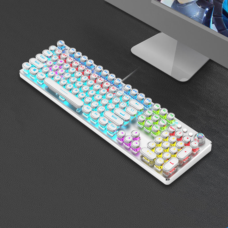 Colorful keyboard on a dark surface with a computer monitor in the background