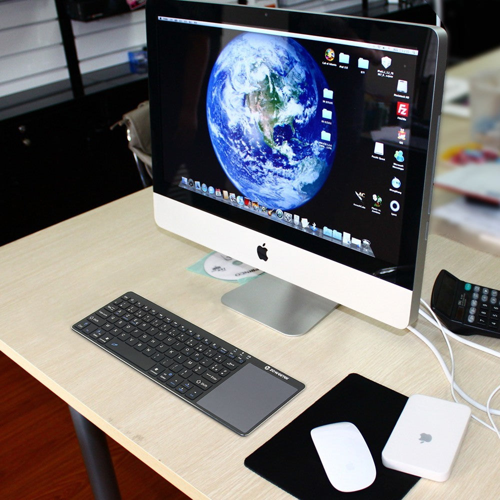Computer setup with monitor, keyboard, mouse, and external hard drive on a desk.
