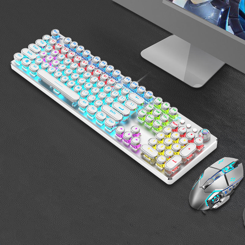 Colorful keyboard and mouse set on a dark surface with a computer monitor in the background.