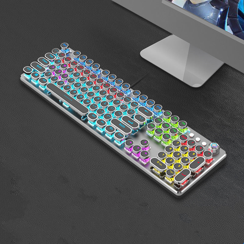 Colorful mechanical keyboard on a dark surface with a computer monitor in the background