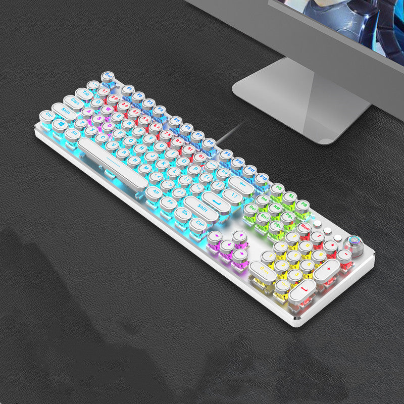 Colorful keyboard on a dark surface with a computer monitor in the background