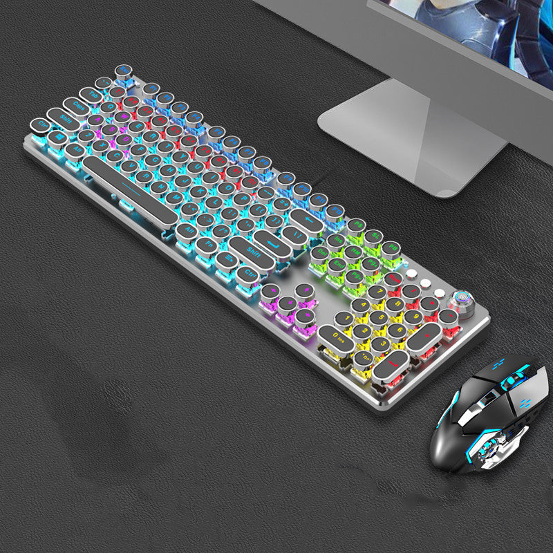 Colorful keyboard and mouse set on a dark surface with a computer monitor in the background