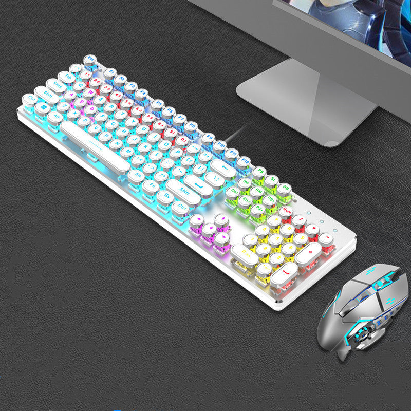 Colorful keyboard and mouse set on a dark surface with a computer monitor in the background.