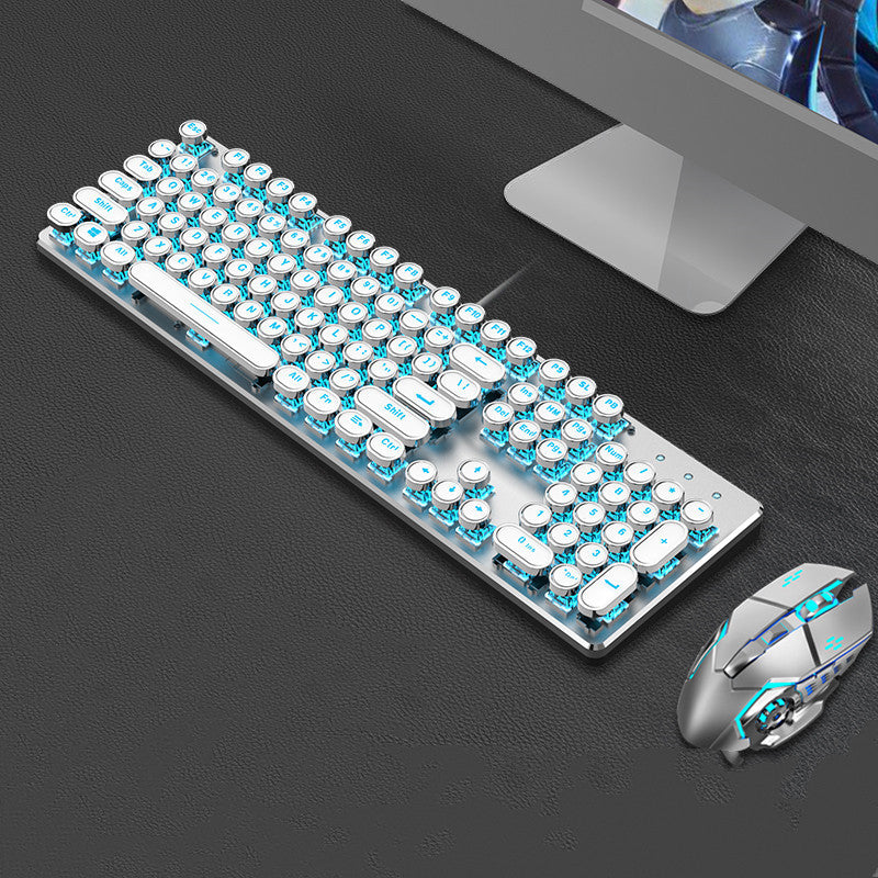 Mechanical keyboard and mouse set on a dark surface with a computer monitor in the background.