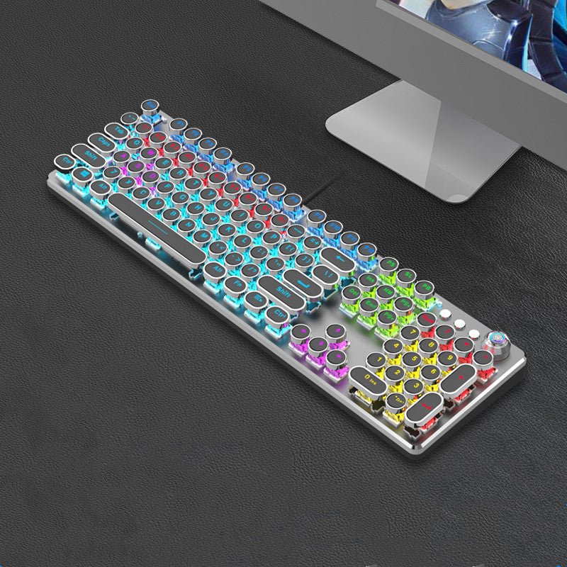 Colorful mechanical keyboard on a dark surface with a computer monitor in the background