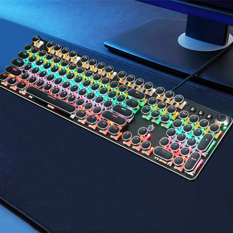 Colorful mechanical keyboard on a dark surface with a computer monitor in the background