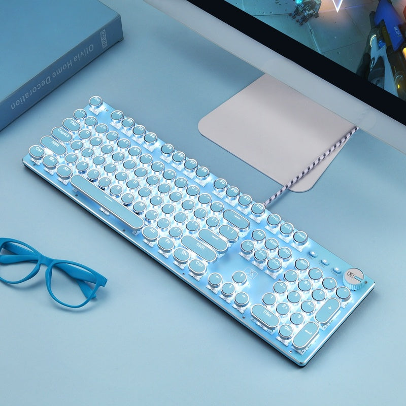 Clear keyboard on a desk with a computer monitor and glasses in the background
