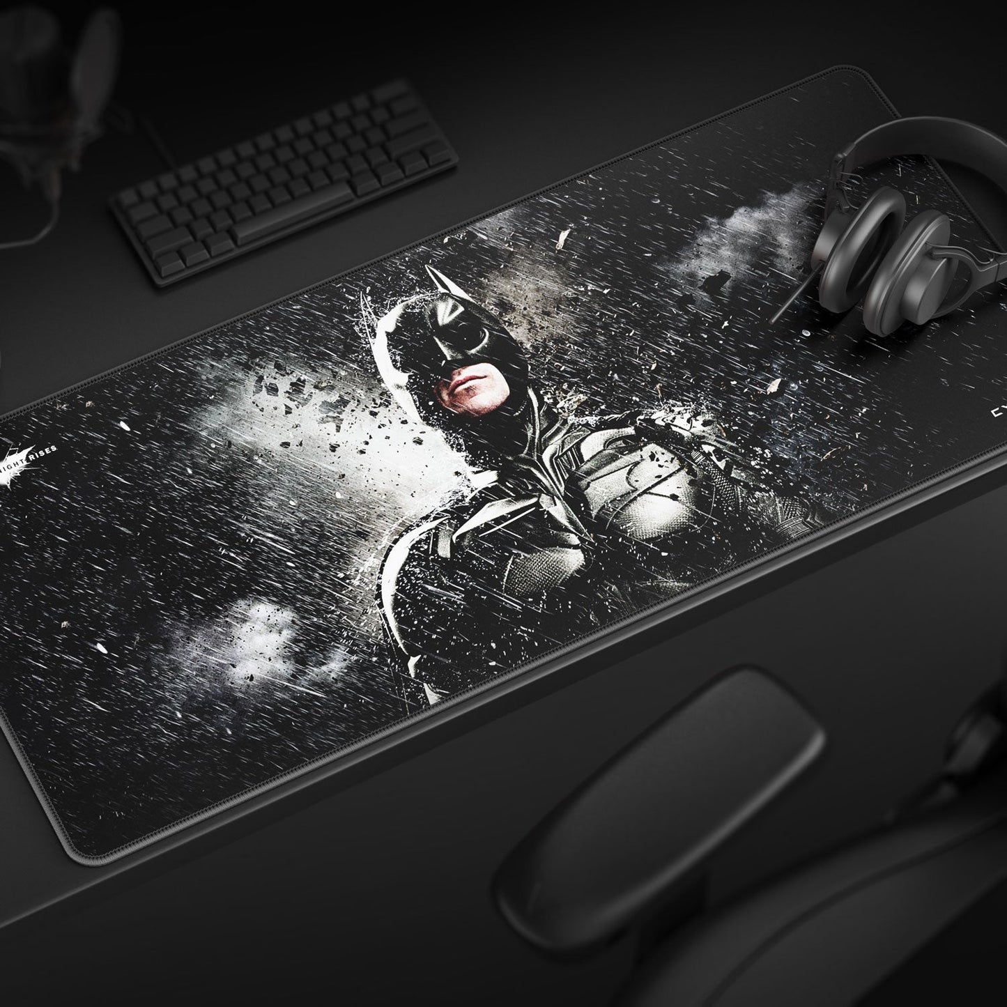 Large desk mat with superhero design on a dark surface with keyboard and mouse.