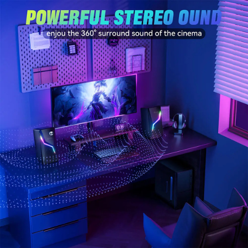 Gaming setup with a monitor, keyboard, and speakers in a room with blue lighting.