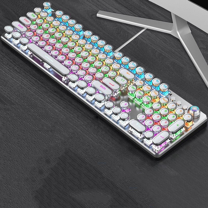 Colorful keyboard on a dark surface with a computer monitor in the background