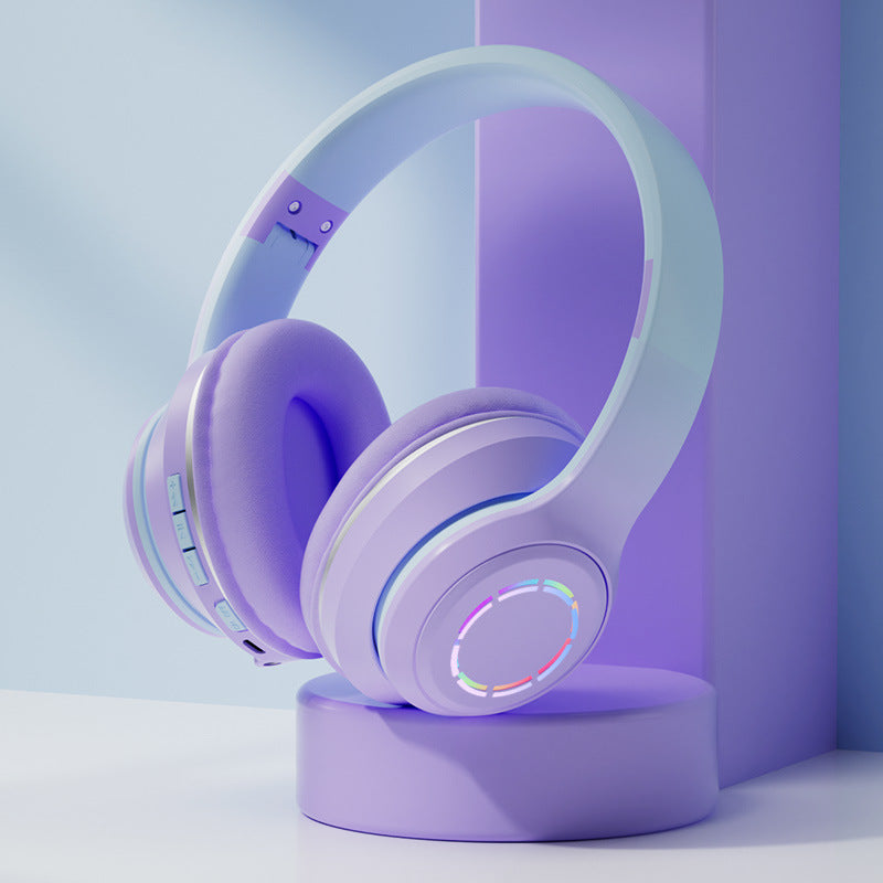 Purple headphones with a colorful light on a purple stand against a light blue background