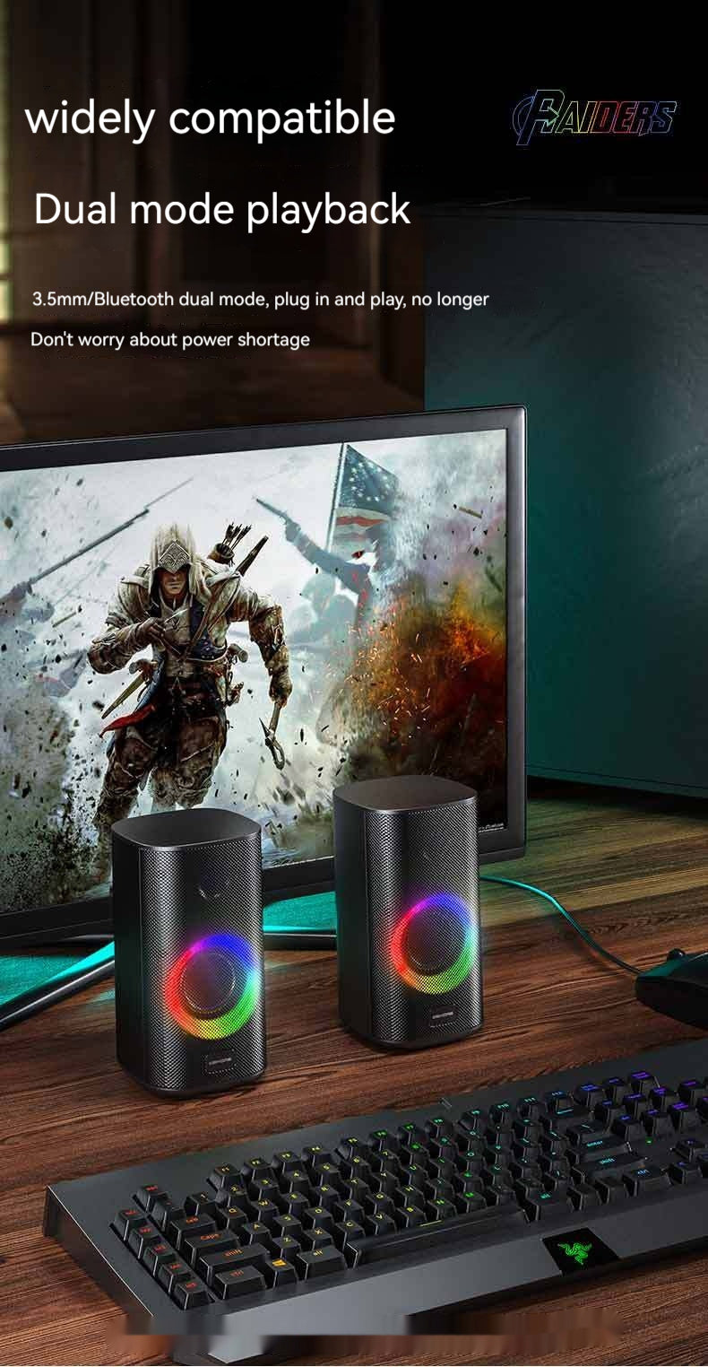 Pair of black gaming desktop speakers with RGB lighting on a desk