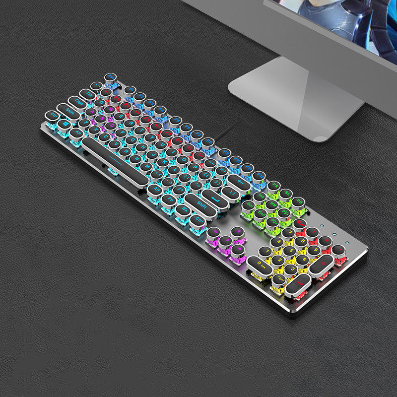 Colorful mechanical keyboard on a dark surface with a computer monitor in the background