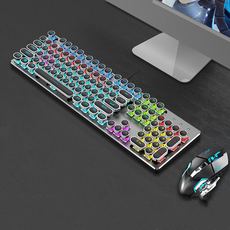 Colorful keyboard and mouse set on a dark surface with a computer monitor in the background.