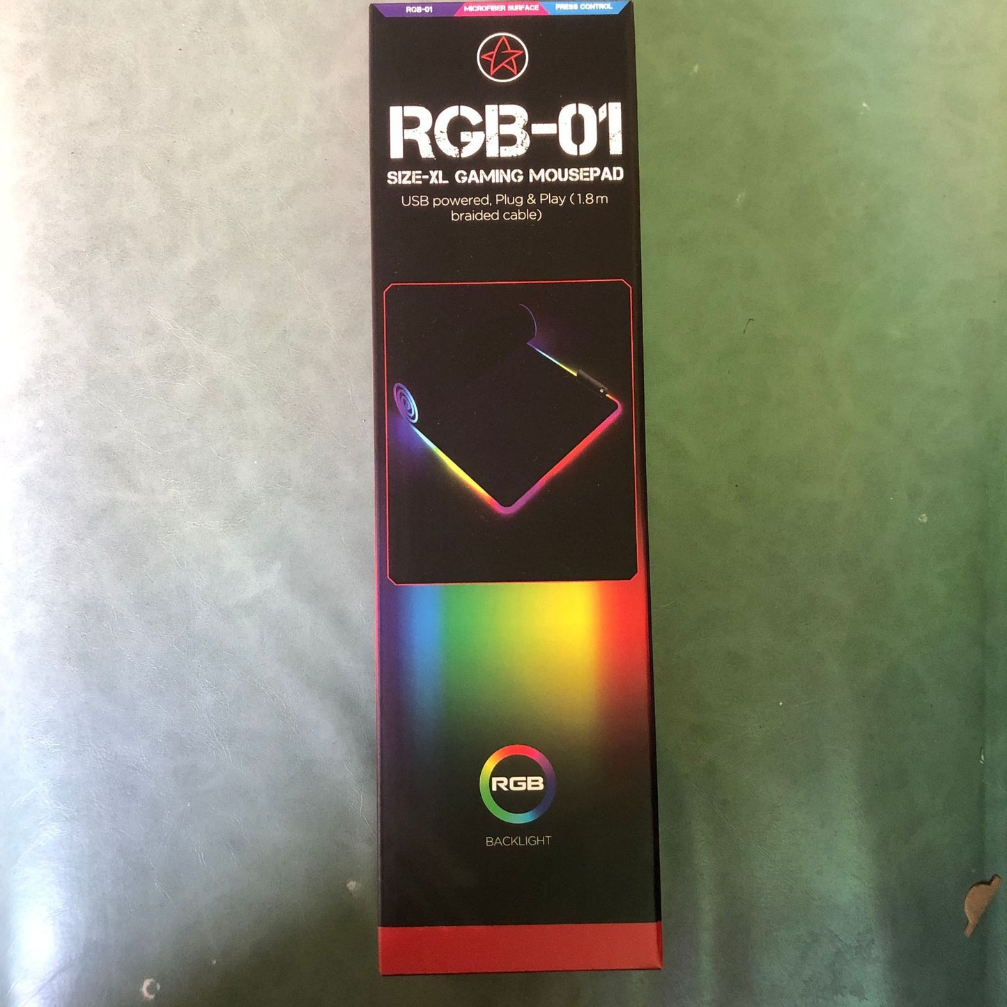 Box of RGB-01 gaming mousepad with rainbow gradient on a metallic surface
