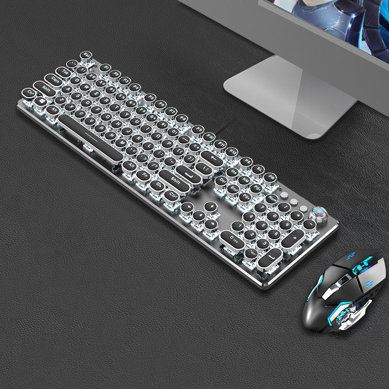 Transparent keyboard and mouse set on a dark surface with a computer monitor in the background.