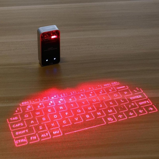 Red laser projection keyboard on a wooden surface with a small device emitting the laser.