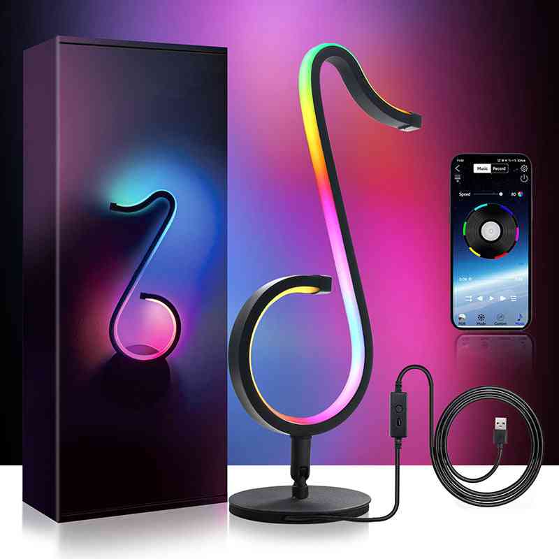 Music note-shaped RGB lamp with packaging, smartphone control app, and USB cable on a dark background