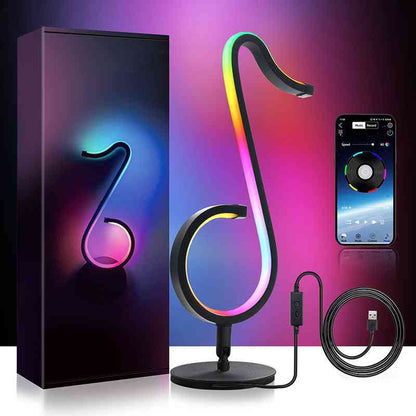 Music note-shaped RGB lamp with packaging, smartphone control app, and USB cable on a dark background