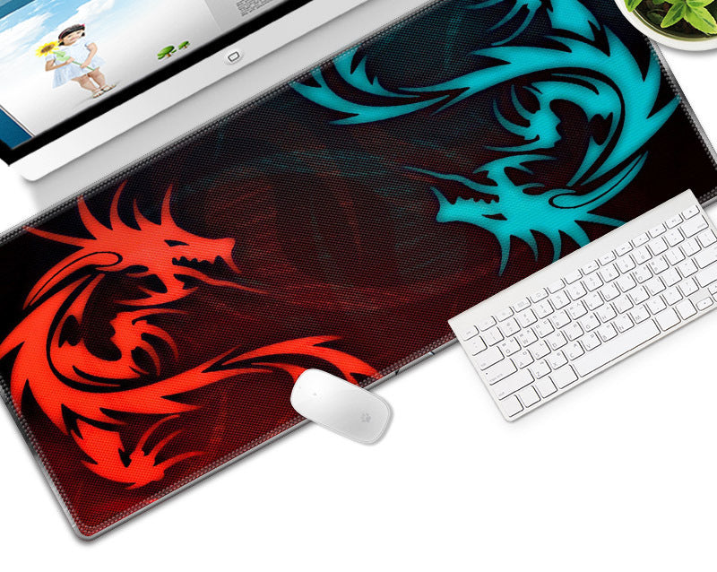 Dragon-themed mouse pad with red and blue dragons on a desk with a computer and keyboard.