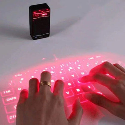 Hands interacting with a virtual red keyboard projected onto a surface, with a small black device emitting red light.