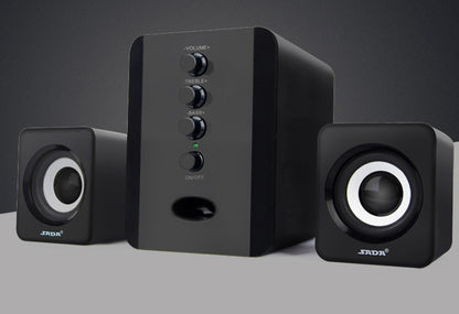 Black computer speakers with control panel on a gray background