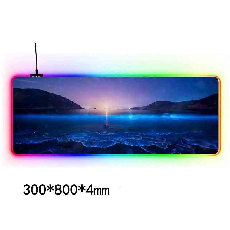 Gaming mouse pad with LED lighting displaying a scenic view of mountains and water.