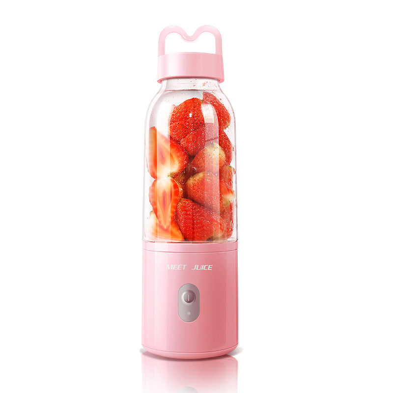 Pink portable blender with strawberries inside on a white background