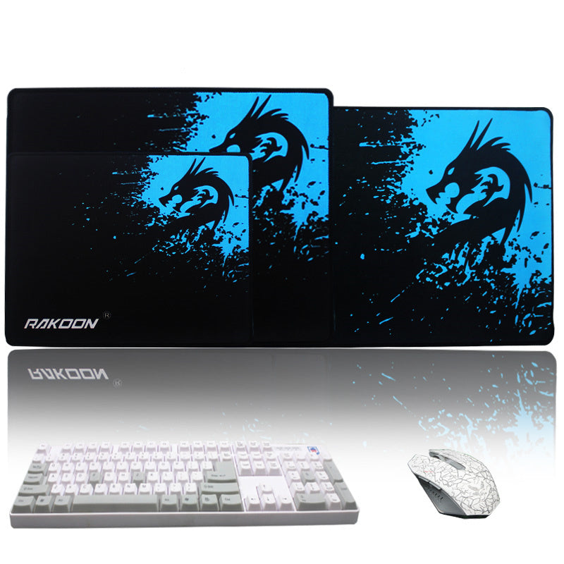 Dragon-themed mouse pad with RAKOON branding, keyboard, and mouse on a white background