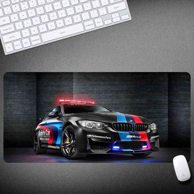 Mouse pad with a BMW car design on a desk with a keyboard and mouse.