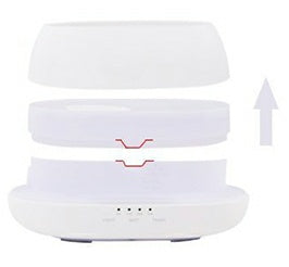 White electronic device with a lid on top, showing a charging indicator.