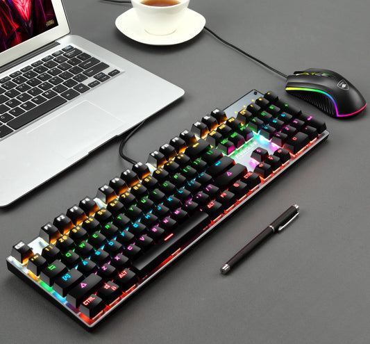 Gaming keyboard, mouse, and laptop on a desk with a pen.