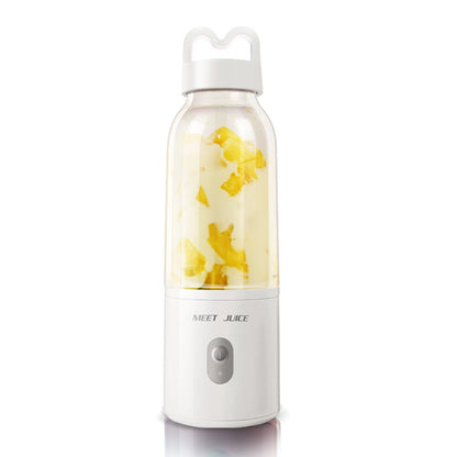 Portable juice maker with fruit pieces inside on a white background