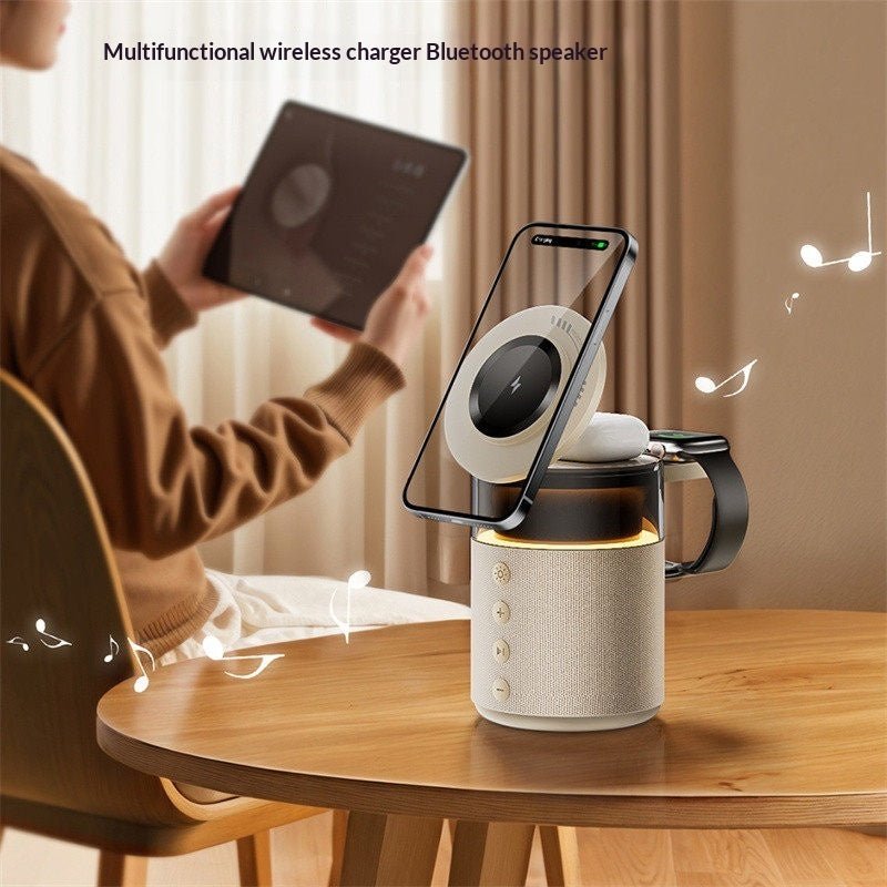 Multifunctional wireless charger Bluetooth speaker on a table with a person using a phone.