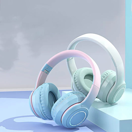 Pair of light blue and pink headphones on a reflective surface with a gradient background