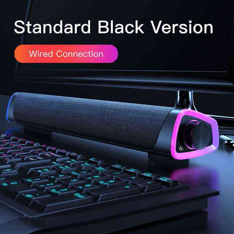 Gaming soundbar with purple accents on a desk with keyboard and monitor