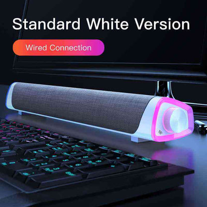 White computer monitor with a keyboard and a white soundbar on a desk.