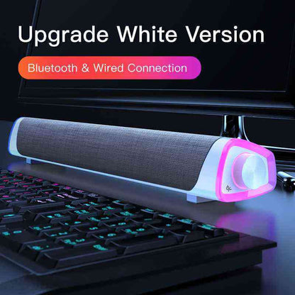 Soundbar with Bluetooth and wired connection on a desk with keyboard and monitor in the background