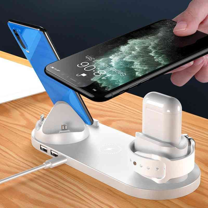 Multi-device charging station with smartphone, tablet, and wireless earbuds on a wooden surface.