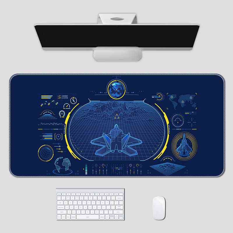 Desk setup with a large blue desk mat featuring technical drawings, a computer monitor, keyboard, and mouse on a white surface.