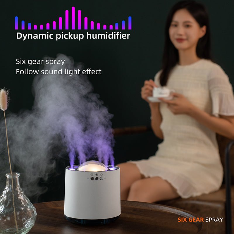 Humidifier with sound light effect on a table, woman holding a cup in the background