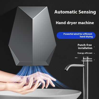 Automatic sensing hand dryer machine with hands being dried, on a black background.