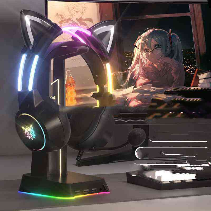 Gaming headset with cat ear design on a desk in front of a computer screen displaying an anime character.