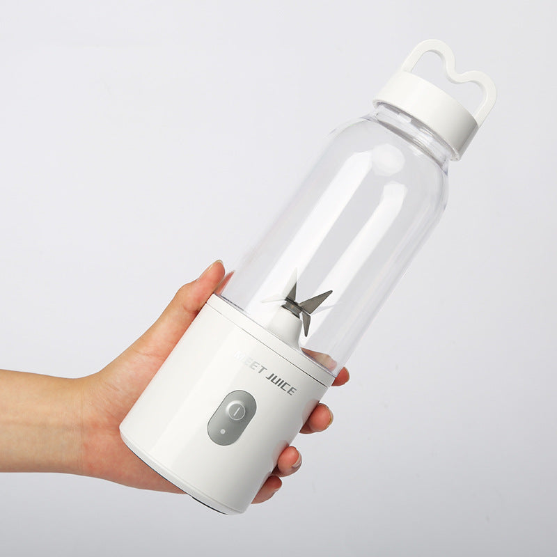 Hand holding a white portable blender on a light gray background