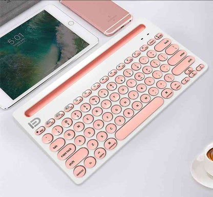 Rose gold keyboard on a white surface with a smartphone and tablet in the background.